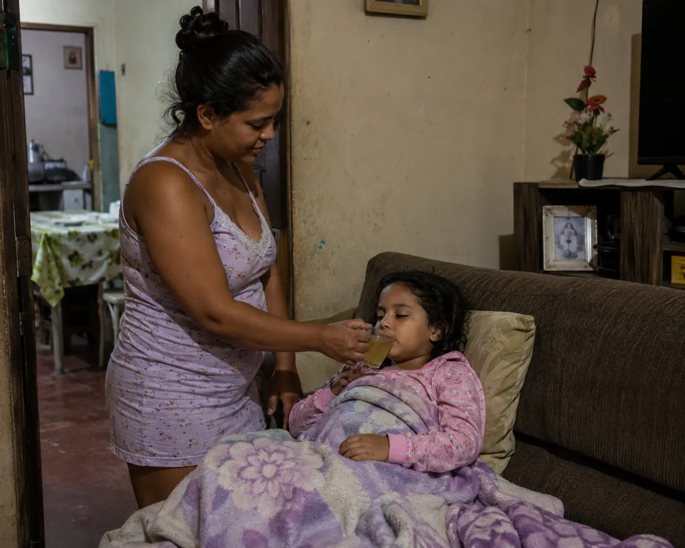 Mãe cuidando da filha doente em casa